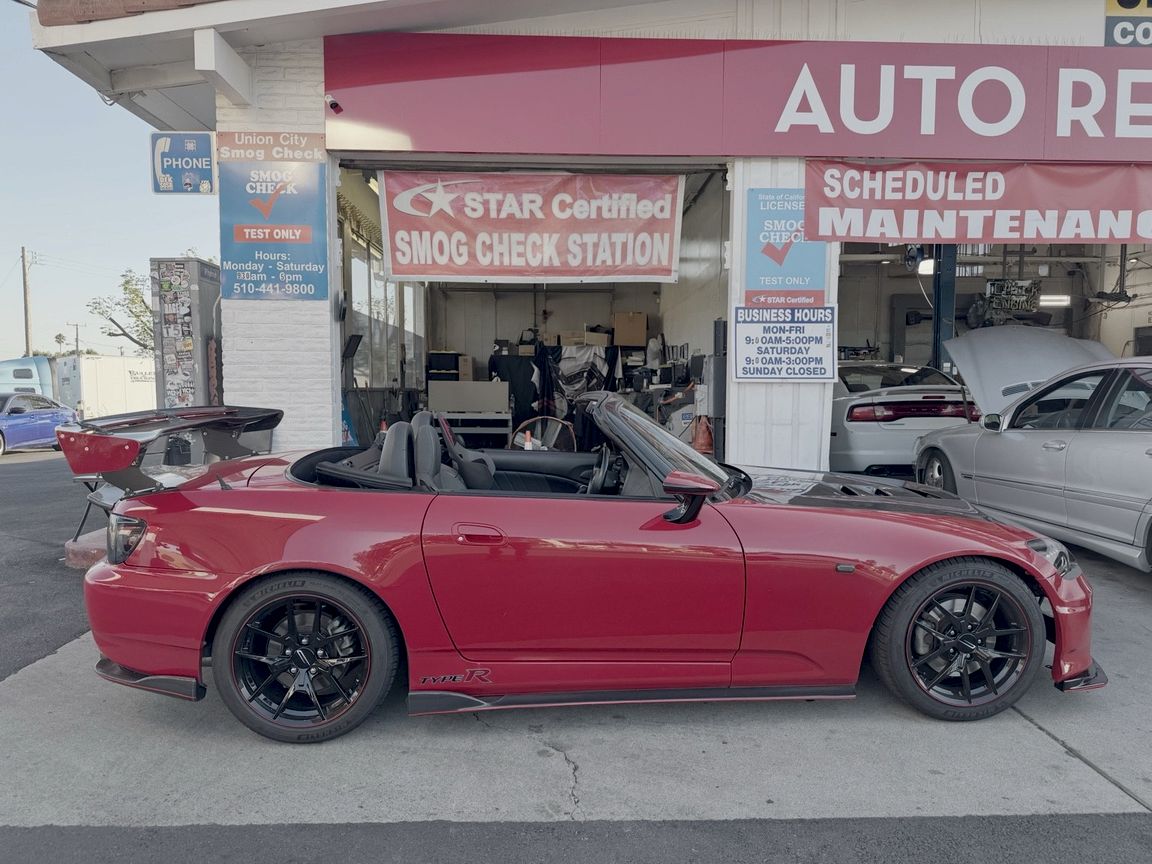 Red Honda S2000 in front of the Union City Smog Check bay, under the STAR Certified Smog Check Station banner
