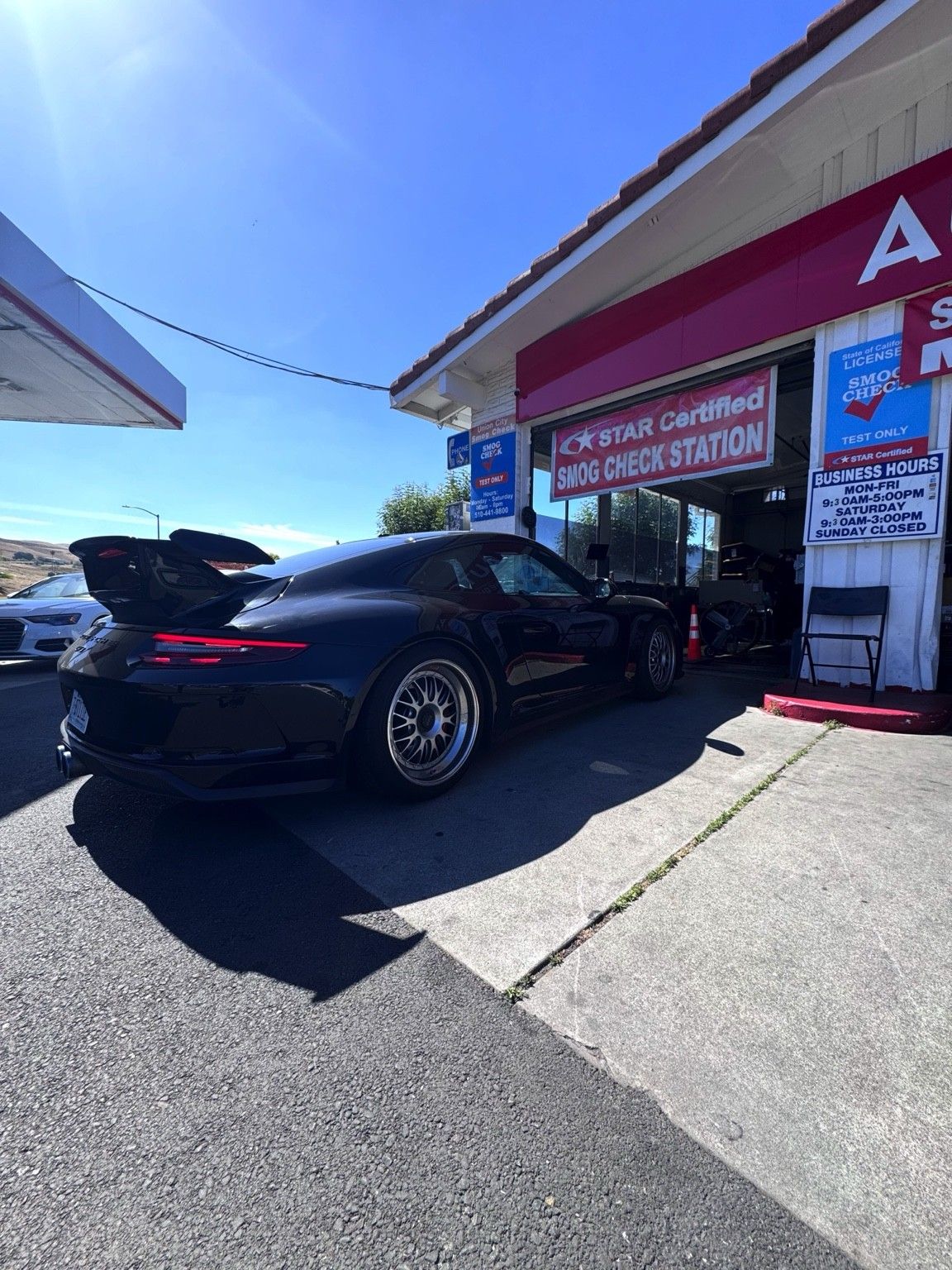 Black Porsche 911 GT3 outside the Union City Smog Check STAR certified bay