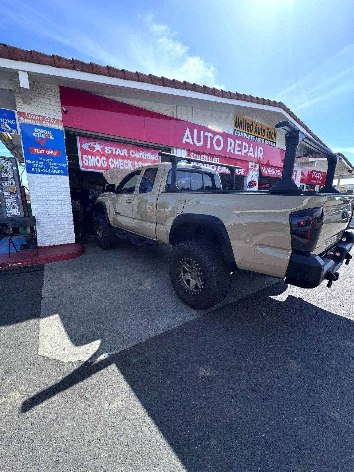 Tan Toyota Tacoma pulling into the Union City Smog Check bay